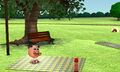 A Mii sitting on a picnic blanket on the hill while another Mii lays on the grass.