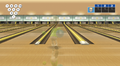 A bowler bowls the bowling ball down the bowling lane